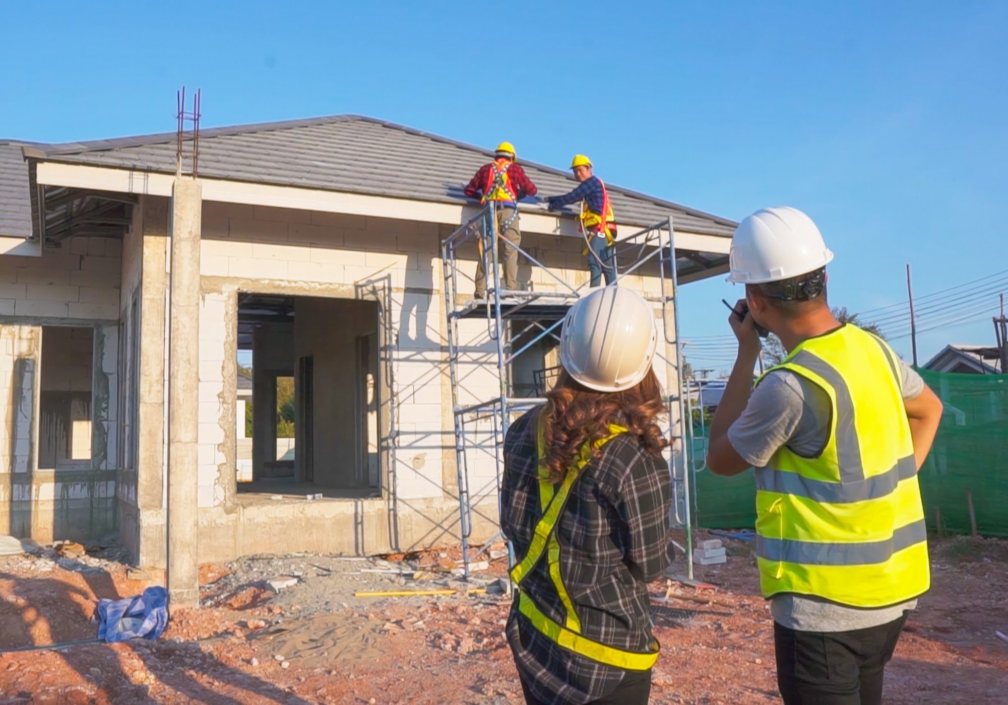 Construction workers building a house with scaffolding.
